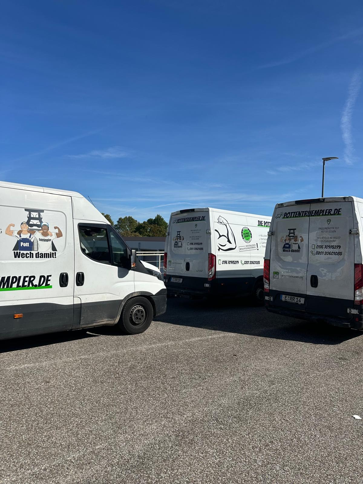 Drei weiße Lieferwagen mit deutschen Texten und Illustrationen sind auf einem Parkplatz unter blauem Himmel geparkt. Die Lieferwagen sind mit Geschäftsanzeigen und Kontaktinformationen beschriftet. Im Hintergrund sind Bäume zu sehen. Drei weiße Lieferwagen mit deutschen Texten und Illustrationen sind auf einem Parkplatz unter blauem Himmel geparkt. Die Lieferwagen sind mit Geschäftsanzeigen und Kontaktinformationen beschriftet. Im Hintergrund sind Bäume zu sehen.